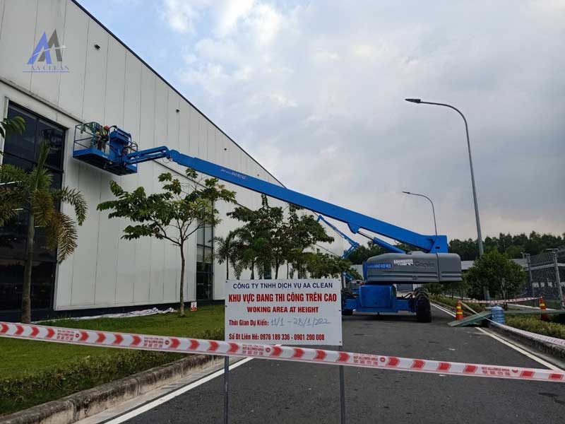 Nhân viên làm sạch tường bên ngoài nhà xưởng
